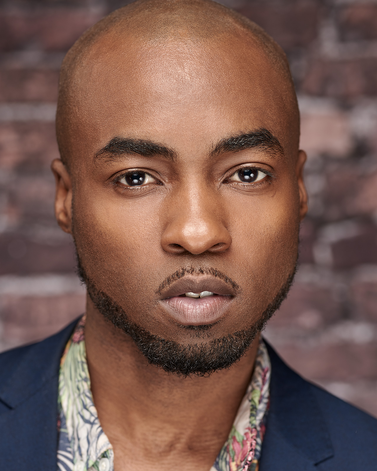 A male model headshot against a brick background made in Los Angeles