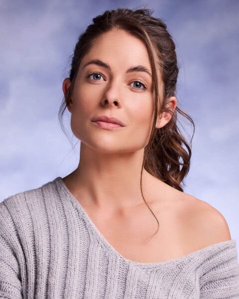 A commercial actor headshot of a woman in a sweater in a studio near Los Angeles