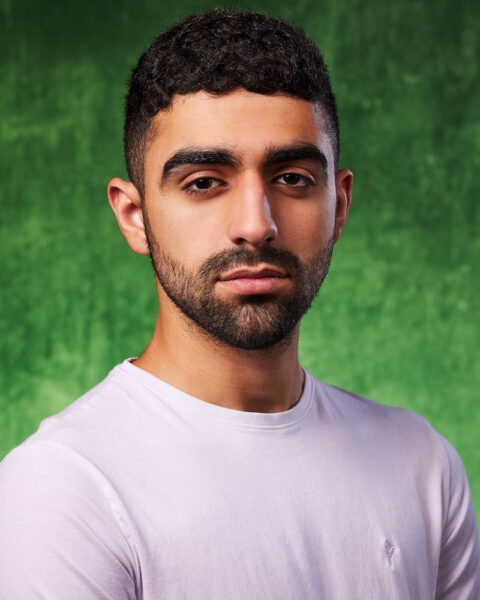 A theatrical actor headshot of a middle eastern man in a studio near Burbank with a green background