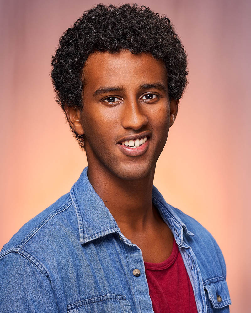 A commercial actor headshot of a man with an overshirt in a studio near Burbank with a tan background