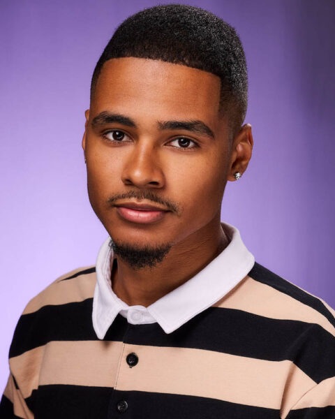 A commercial actor headshot of a black man in a studio near Los Angeles with a purple background