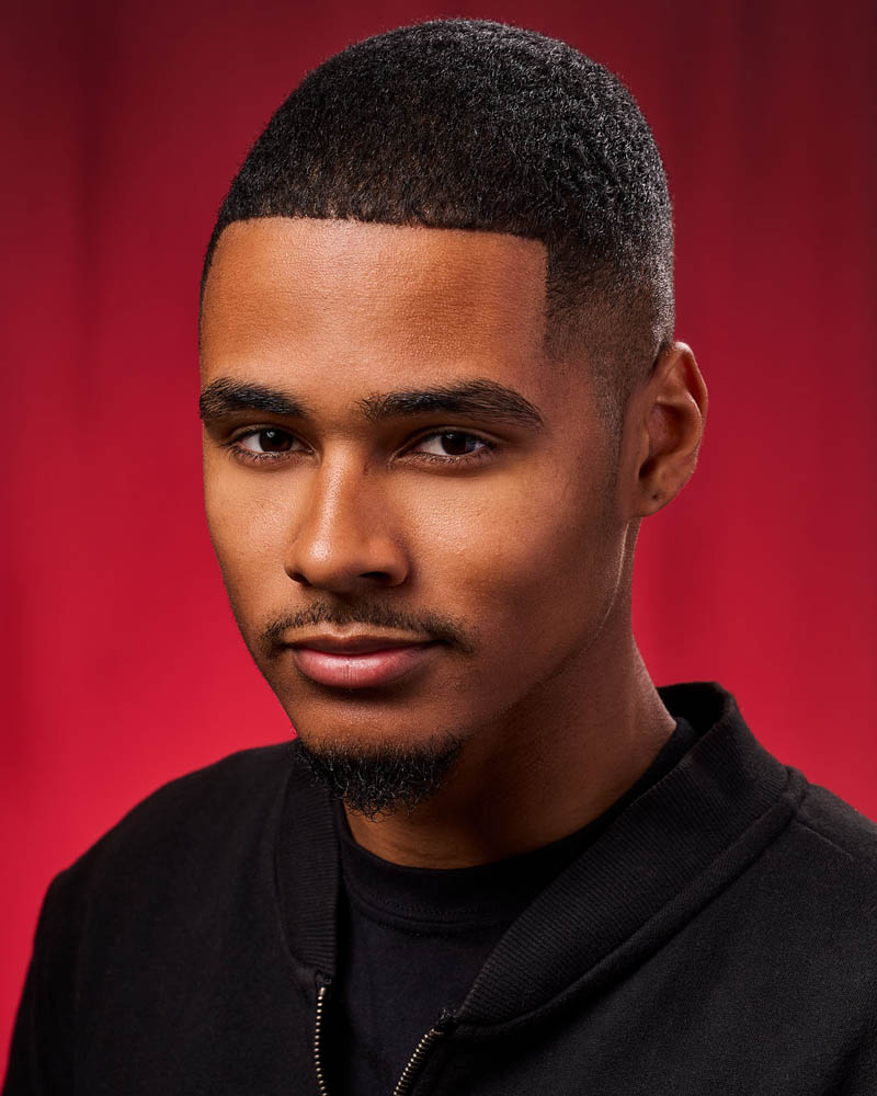 A sensual actor headshot of a black man in a studio near Los Angeles with a red background