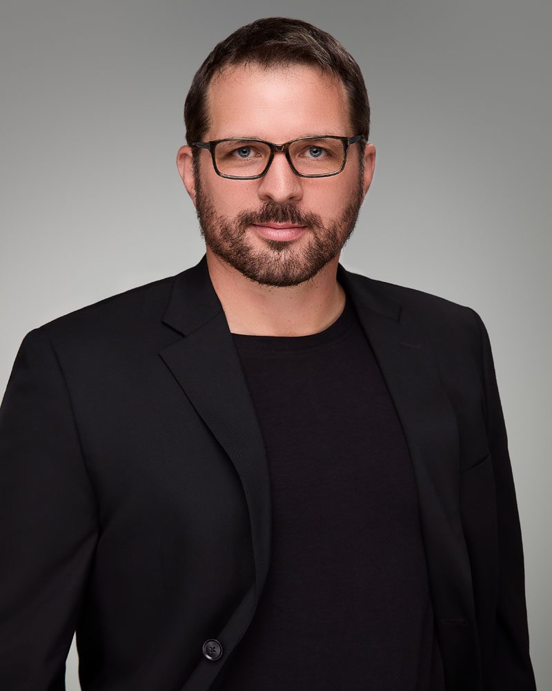 studio headshot of a man in a black business suit in Los Angeles