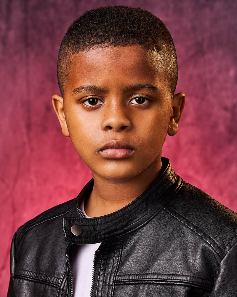 young boy theatrical acting headshot in a studio near South Pasadena with a red background