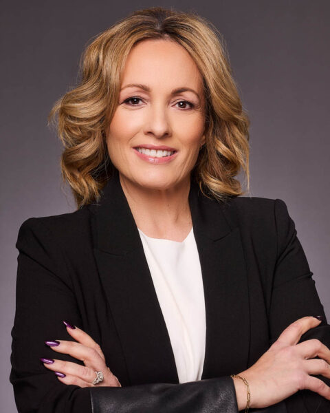 A real estate agent headshot of a woman in a suit in studio near Los Angeles