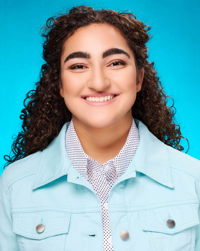 teen girl commercial acting headshot in a studio near Los Angeles with a teal background