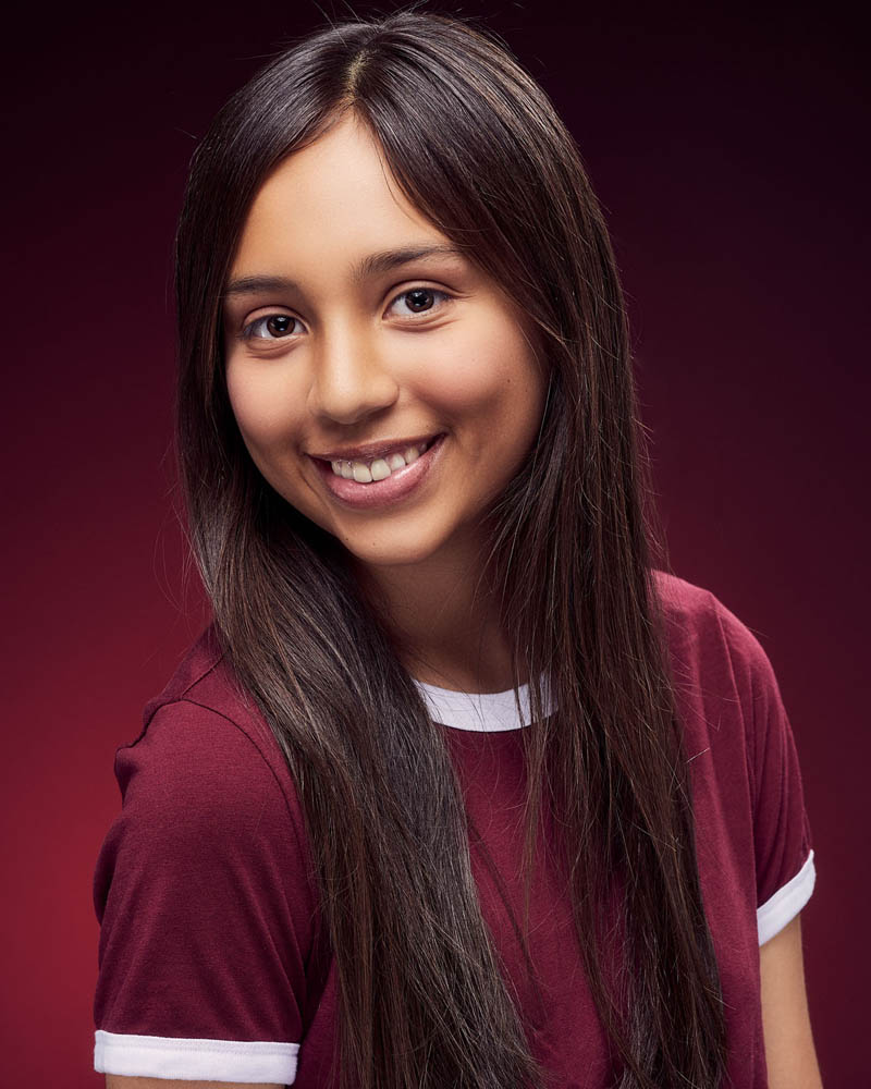 teen girl acting headshot in a studio in Los Angeles with a red background